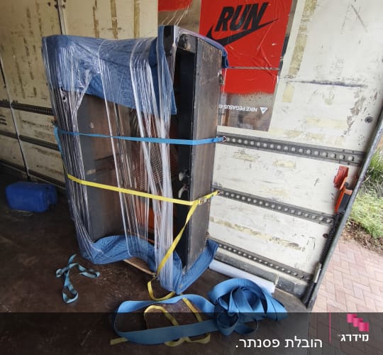 רהיט עטוף ומאובטח ברצועות בתוך משאית הובלה